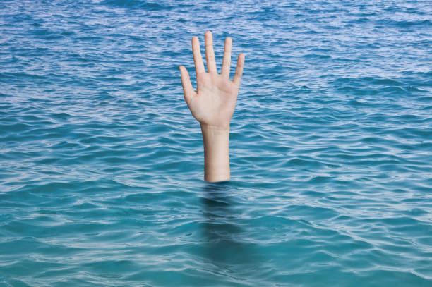 istock Sinking hand in ocean's water needing help. Drowning person Emergency, failure and help concept 1271503864