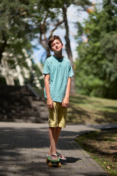 istock Full-length young handsome guy rides a skateboard on a sunny day. Summer walks. 1271505785