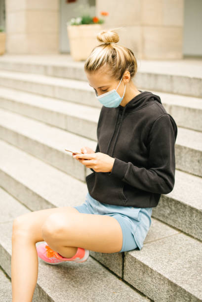 istock Young blonde woman wearing mask using phone. 1271506864