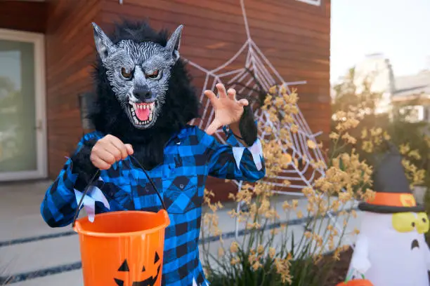 Portrait Of Boy Wearing Fancy Dress Outside House Collecting Candy For Trick Or Treat