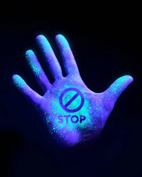 Photo of Hand Glowing With Ultra Violet Light Showing Bacteria