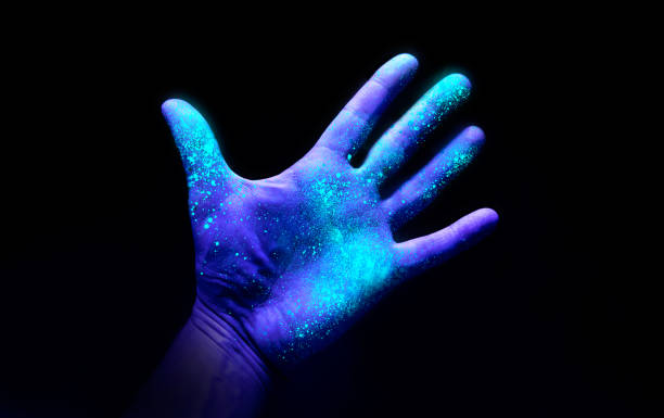 Ultraviolet Light On a Hand Showing Bacteria Growth UV Ultraviolet light on a hand illustrating the effect of bacteria and viruses on asurface that has not been washed showing the importance of good hygiene and hand washing espically during a pandemic such as Covid-19. ultraviolet stock pictures, royalty-free photos & images