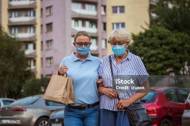 Home Caregiver Helping Senior Woman With Walking Outdoors Stock Photo - Download Image Now