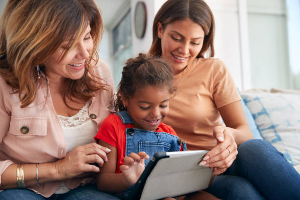 istock Multi-Generation Female Hispanic Family Sitting On Sofa At Home Using Digital Tablet 1271511017