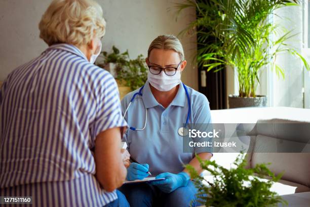 Home Caregiver Visiting Senior Woman During Coronavirus Pandemic Stock Photo - Download Image Now