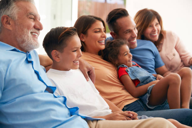 istock Multi-Generation Hispanic Family Relaxing At Home Sitting On Sofa Watching TV Together 1271511220