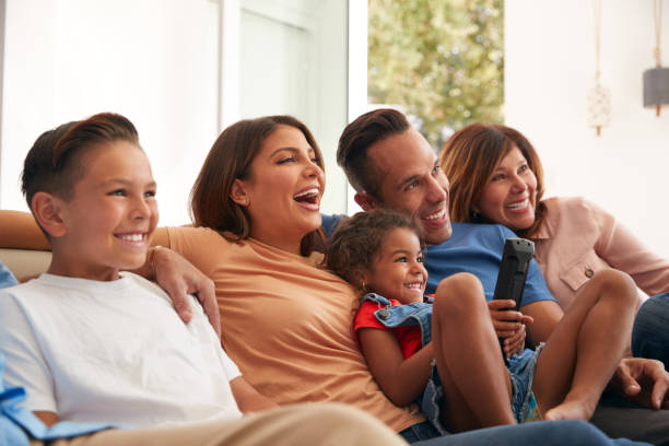 istock Multi-Generation Hispanic Family Relaxing At Home Sitting On Sofa Watching TV Together 1271511221