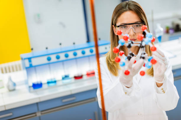 istock Female chemist hold molecular model in the lab 1271511420
