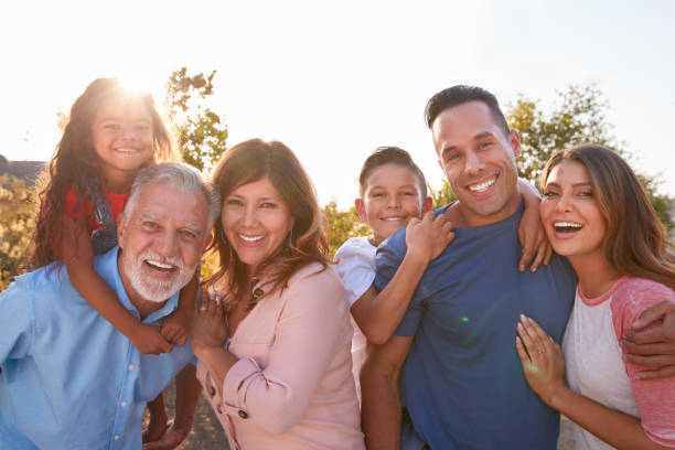 Portrait Of Multi-Generation Hispanic Family Relaxing In Garden At Home Together Portrait Of Multi-Generation Hispanic Family Relaxing In Garden At Home Together 60 64 years photos stock pictures, royalty-free photos & images