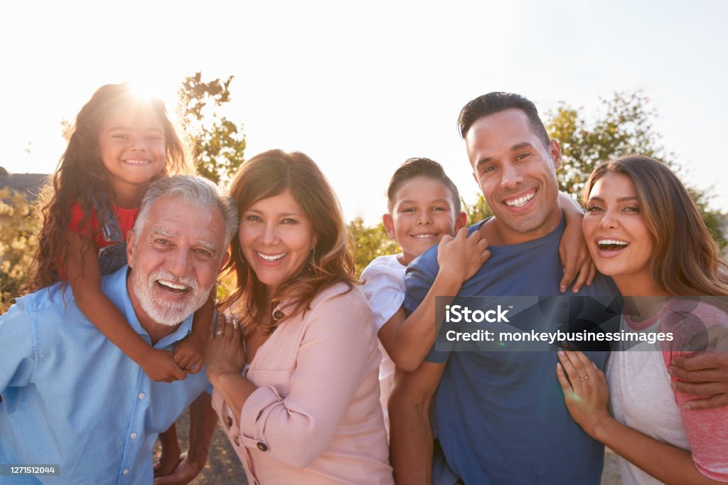 Retrato de família hispânica de várias gerações relaxando no jardim em casa juntos - Foto de stock de Família royalty-free