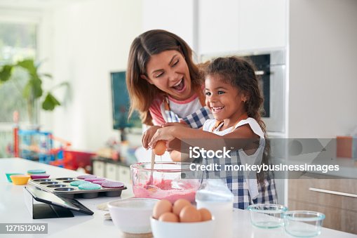 istock Hispanic Mother And Daughter Having Fun In Kitchen At Making Cake Together 1271512049