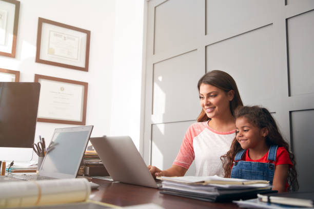 istock Hispanic Mother And Daughter Using Laptop In Home Office Together 1271512062