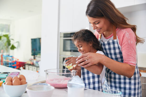 istock Hispanic Mother And Daughter Having Fun In Kitchen At Making Cake Together 1271512117