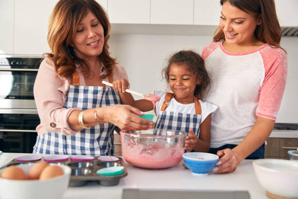 istock Multi-Generation Hispanic Female Family Having Fun In Kitchen At Making Cake Together 1271512555