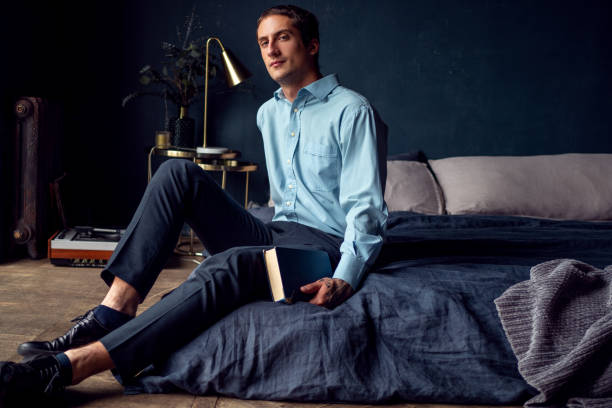 istock young man with a book is sitting on the bed, a portrait 1271513992