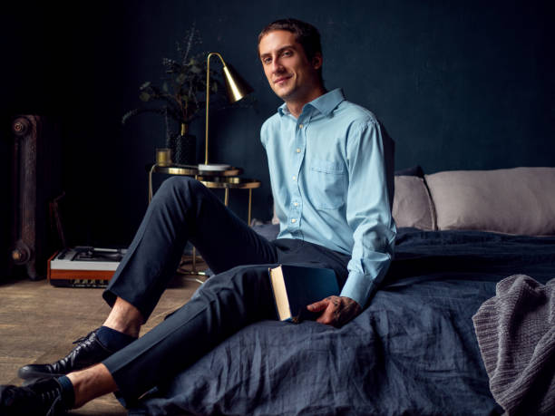 istock young man with a book is sitting on the bed, a portrait 1271514004