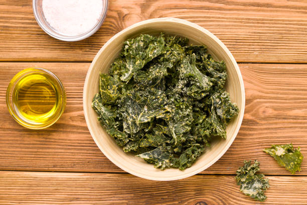 istock Kale chips on wooden background close-up, top view 1271515121