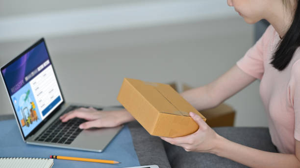 istock young business owner using a computer sitting at home, Sme concept. 1271515125
