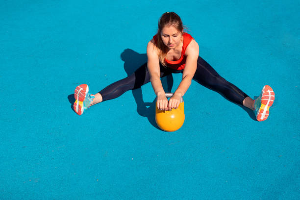 istock Young female athlete doing workout, training with a kettlebell in the open air. 1271515578