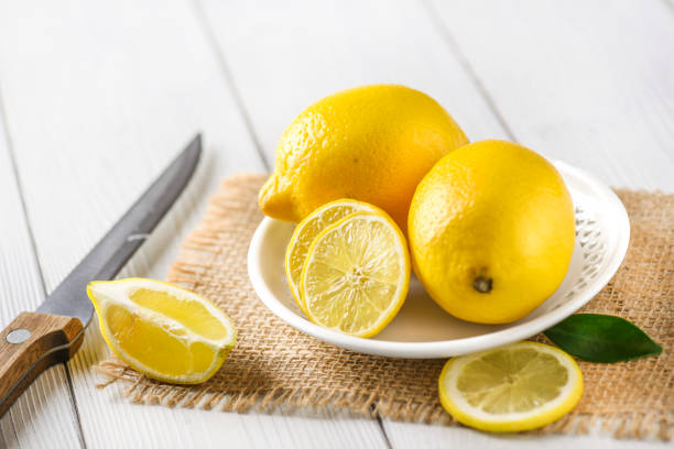 istock Fresh juicy lemons on white rustic table. 1271515796