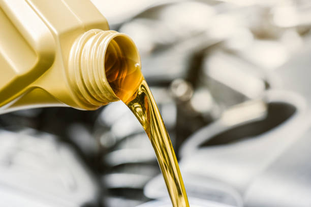 istock Pour yellow motor oil into car engine. 1271515988