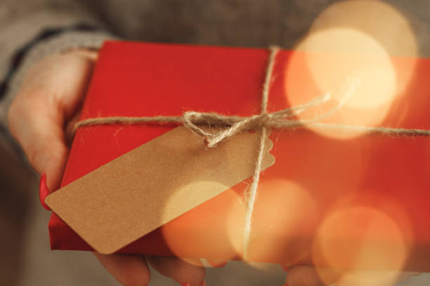 istock Female hands in sweater holding wrapped Christmas gift 1271516740
