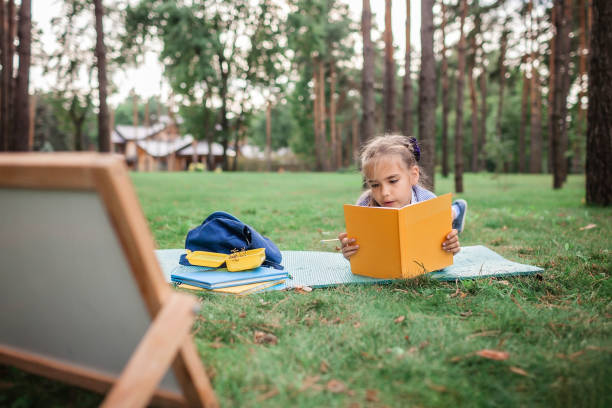 istock Back to school. Elementary scholars sitting on the grass during their open-air class 1271516980