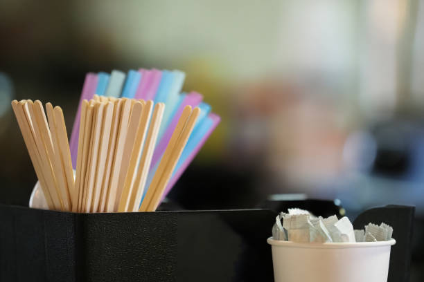istock Straws on a coffee bar counter. Plastic straw, wooden stirrer, and sugar sticks 1271518345
