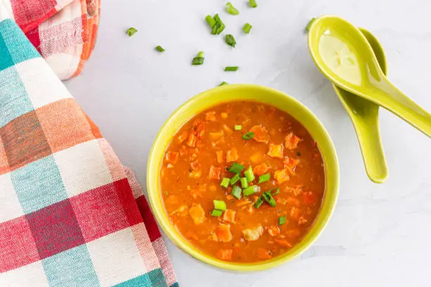 Vegan Vegetable Soup in a Bowl with Spoons on White Background Top Down Photo