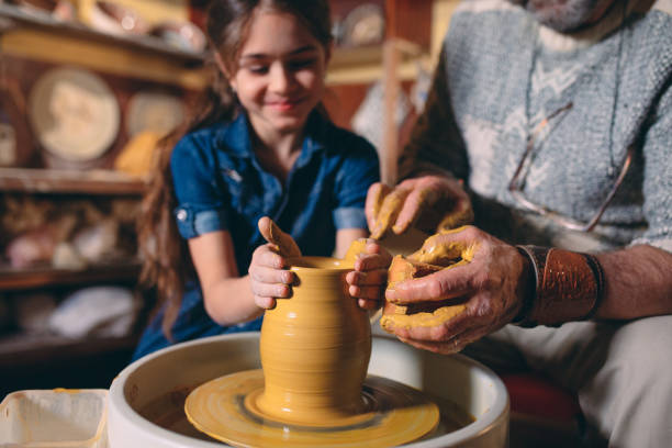 Pottery workshop. Grandpa teaches granddaughter pottery. Clay modeling