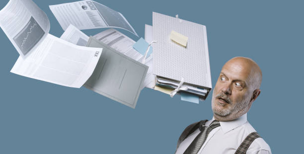 istock Paperwork hitting a businessman's head 1271526130