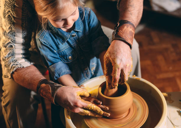 istock Pottery workshop. Grandpa teaches granddaughter pottery. Clay modeling 1271526134