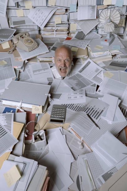 istock Screaming businessman drowning under a lot of paperwork 1271526344