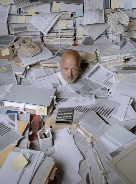 istock Disappointed stressed businessman overwhelmed by paperwork 1271526420