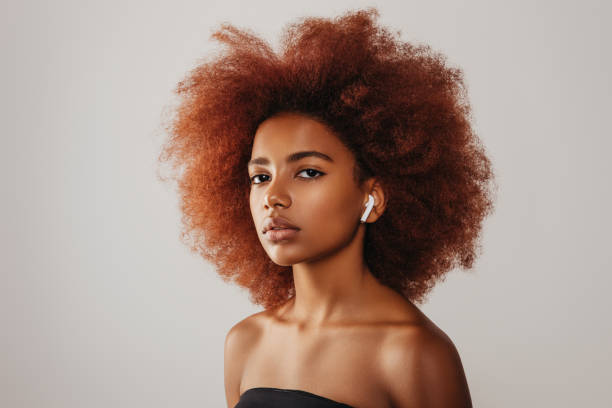 istock Beautiful afro girl using wireless earphones 1271526604