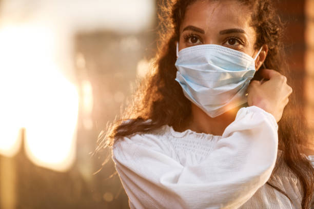 istock Beautiful young woman taking her protective face mask off 1271527391