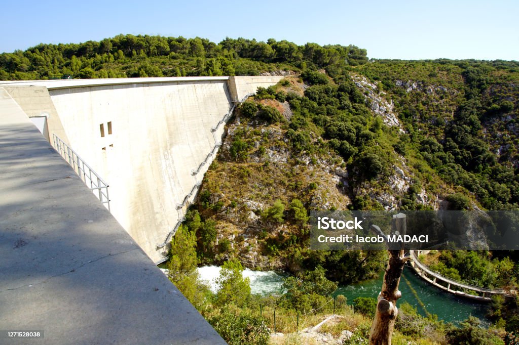 The Bimont Dam near Aix-en-Provence, France The Bimont dam was designed by the Coyne et Bellier design office and built from 1946 to 1951 under the direction of engineer Joseph Rigaud.
It is located in the municipality of Saint-Marc-Jaumegarde near Aix-en-Provence in the South of France.
It is the starting point of several hiking trails through typical landscapes painted by Paul Cézanne, including the main path leading to the top of the Sainte-Victoire mountain. Aix-en-Provence Stock Photo