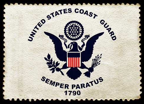 United States Coast Guard flag on the old grunge postage stamp isolated on black background. Texture of old paper