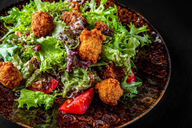 istock Caesar salad with croutons, cheese, eggs, tomatoes and grilled chicken on wooden table. 1271533357