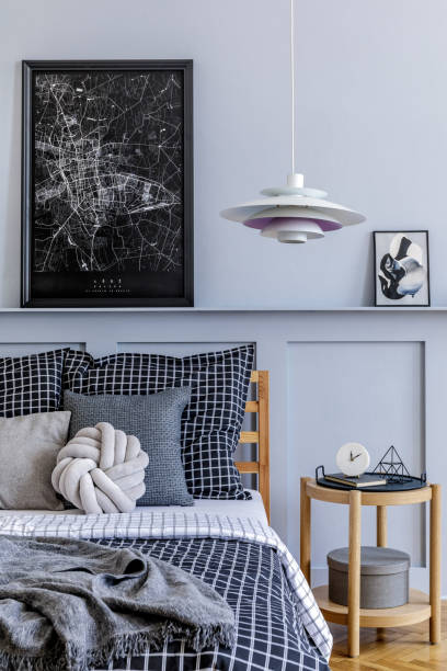 istock Stylish scandinavian bedroom interior with design coffee table, mock up picture frames, book, decoration, personal accessories, beautiful bed sheets, blanket and pillows. 1271533473