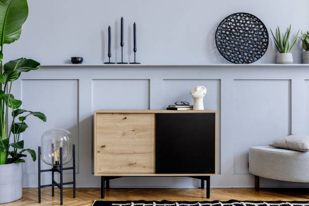 istock Modern scandinavian home interior with design wooden commode, grey pouf, cacti, plants, decoration, lamp, shelf and personal accessories in stylish home decor. 1271533678