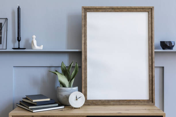 istock Modern scandinavian home interior with mock up poster frame, design wooden commode, candlestick, cacti, book, decoration, shelf and personal accessories in stylish home decor. 1271533812