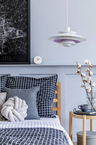 istock Stylish scandinavian bedroom interior with design coffee table, mock up picture frames, book, decoration, personal accessories, beautiful bed sheets, blanket and pillows. 1271534105