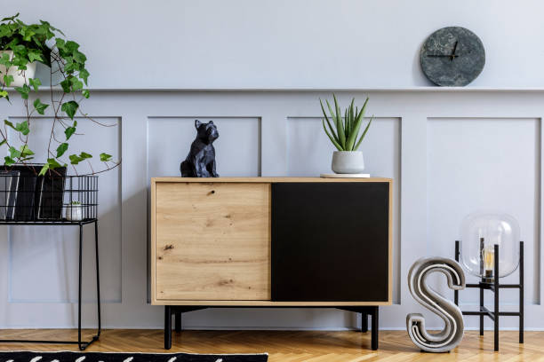 istock Modern scandinavian home interior with design wooden commode, grey pouf, cacti, plants, decoration, lamp, shelf and personal accessories in stylish home decor. 1271534109