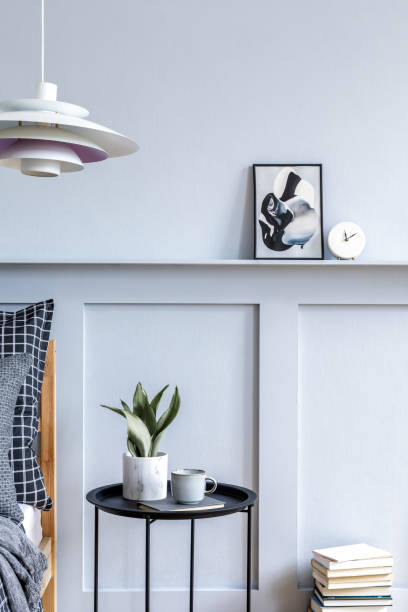 istock Stylish scandinavian bedroom interior with design coffee table, mock up picture frames, book, decoration, personal accessories, beautiful bed sheets, blanket and pillows. 1271534114