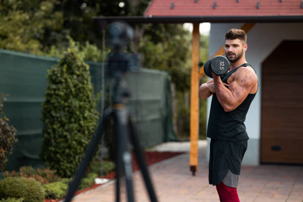istock Male athlete doing exercise in backyard and filming vlog. 1271537403
