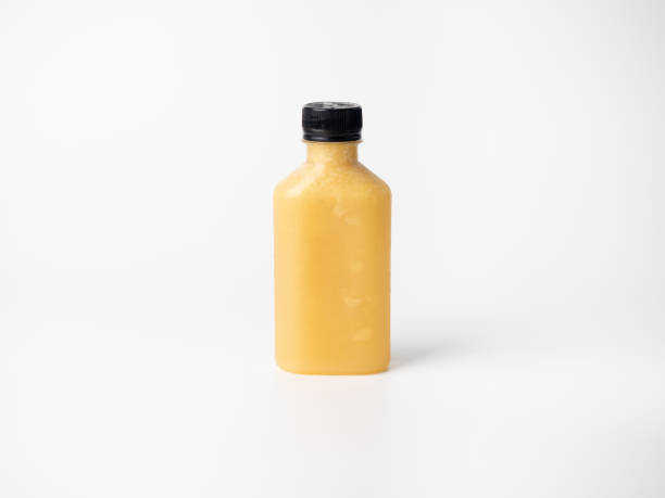 istock orange pastel color drink in plastic bottle container with empty logo label. mixed many vegetables and fruits smoothie juice on studio background. 1271537792