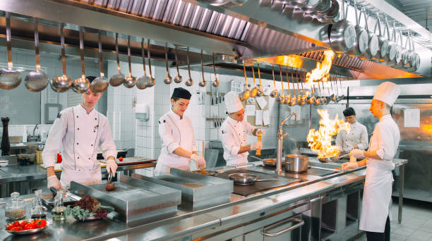 Modern kitchen. Cooks prepare meals on the stove in the kitchen of the restaurant or hotel. The fire in the kitchen. stock photo