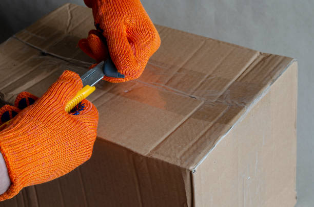 istock A worker wearing protective gloves changes the dull blade of a knife. 1271542015