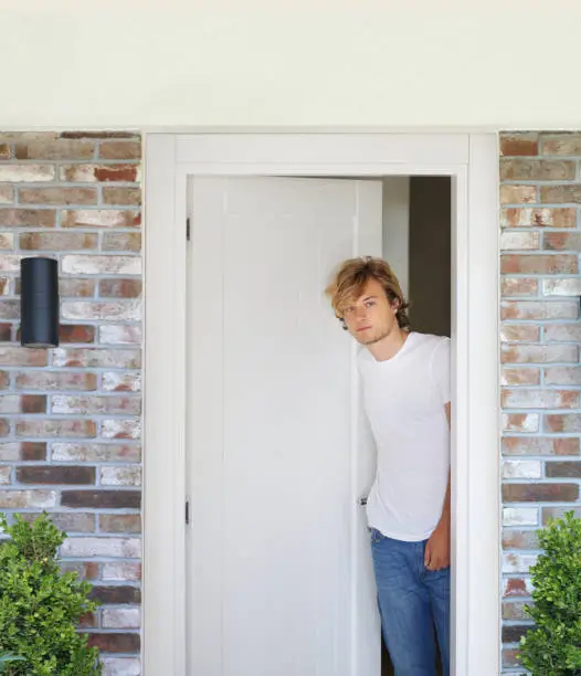 Photo of Man opening the door of him home.